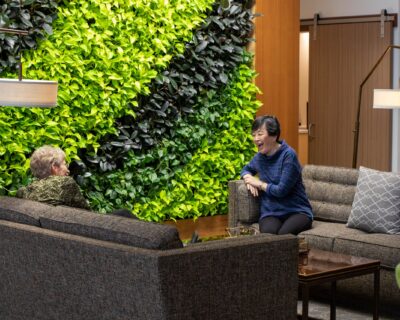 JILL MCKEOWN (RIGHT) AND MITZI SAKATA (LEFT) DISCUSS THEIR LEGACY
WITH COKESBURY VILLAGE IN FRONT OF THE LIVING PLANT WALL.