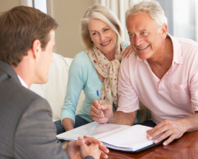 Senior Couple Meeting With Financial Advisor At Home